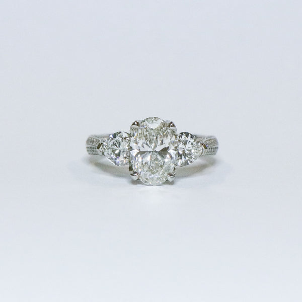 Oval diamond with heart side diamonds ring