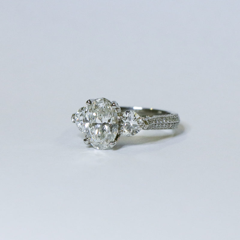 Oval diamond ring with heart side diamonds.
