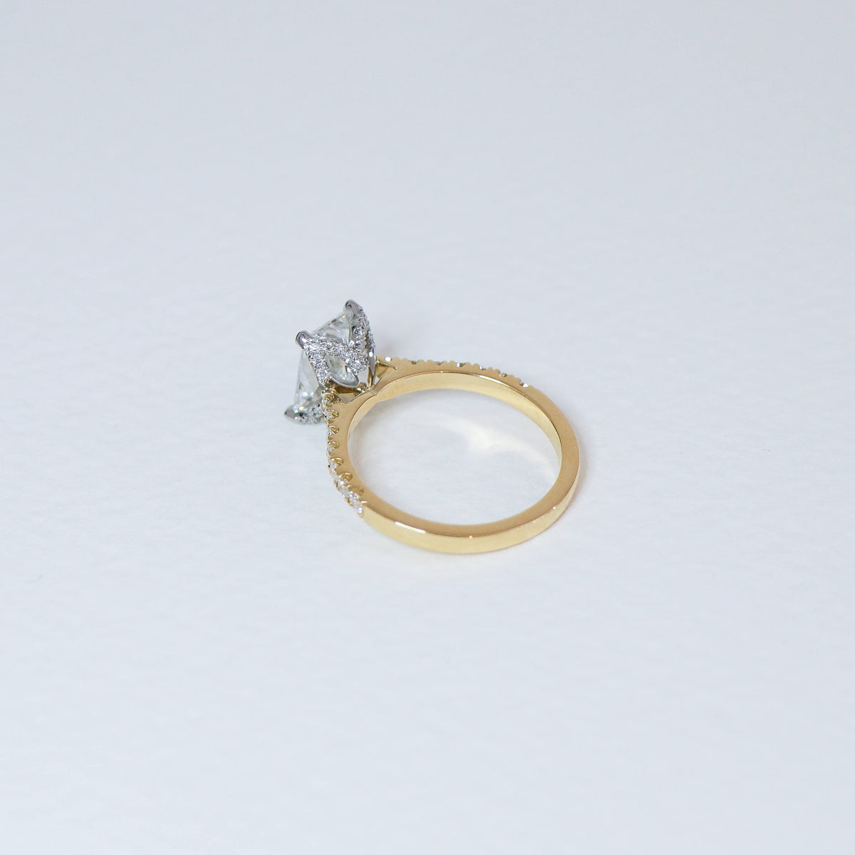 Radiant cut diamond fleur ring with diamond set band.